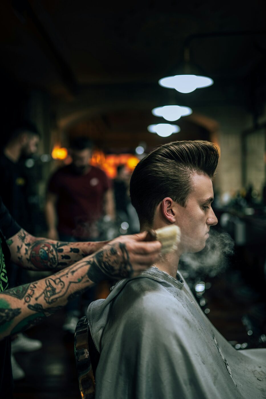 Barbeiro finalizando um corte na Barbearia Cardoso
